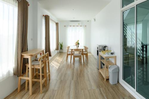 a living room with a table and chairs and a kitchen at Munruk Hostel in Prachuap Khiri Khan