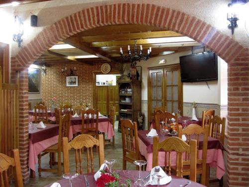 comedor con mesas y sillas y TV en El Portal De Las Arribes, en Aldeadávila de la Ribera