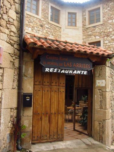 una entrada a un edificio con puerta de madera en El Portal De Las Arribes, en Aldeadávila de la Ribera