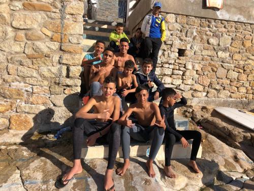 a group of young men sitting on the stairs at Surf & Skate in Taghazout