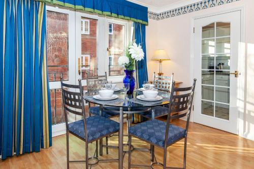 uma sala de jantar com uma mesa de vidro e cadeiras em Churchill Way Suite em Basingstoke