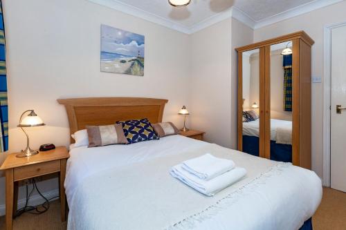 um quarto com uma cama com 2 candeeiros e um espelho em Churchill Way Suite em Basingstoke