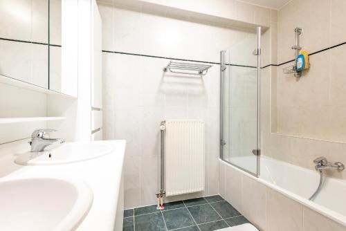 bagno bianco con lavandino e doccia di Centrally located apartment in Knokke a Knokke-Heist