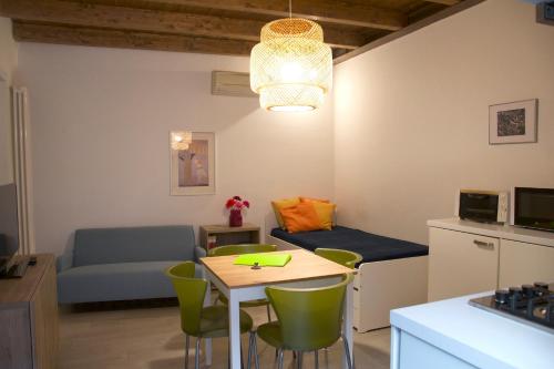 ein kleines Wohnzimmer mit einem Tisch und einem Sofa in der Unterkunft CaseOspitali - CASA CARAMELLI bilocale in corte storica in Cernusco sul Naviglio