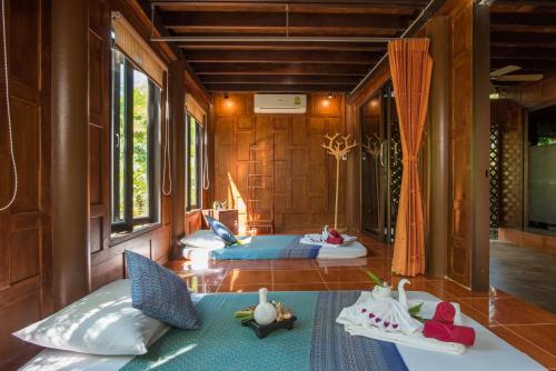 ein Zimmer mit drei Betten mit Puppen auf dem Boden in der Unterkunft ThaiLife Wellness & Meditation Resort- SHA Plus in Khao Lak