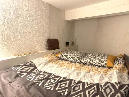 une chambre avec un lit avec une couette dessus dans l'établissement Gîte du Vieux Lyon, à Lyon