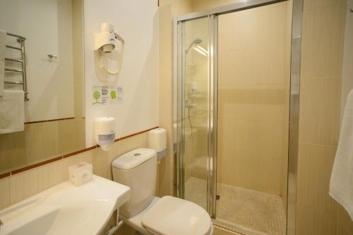 a bathroom with a shower and a toilet and a sink at Optima Collection Kharkiv Hotel in Kharkiv