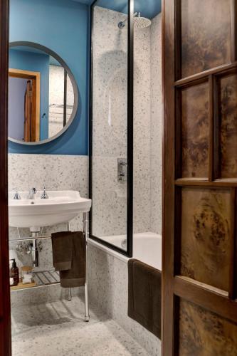 a bathroom with a sink and a tub and a mirror at Luxury Trevi House in Rome