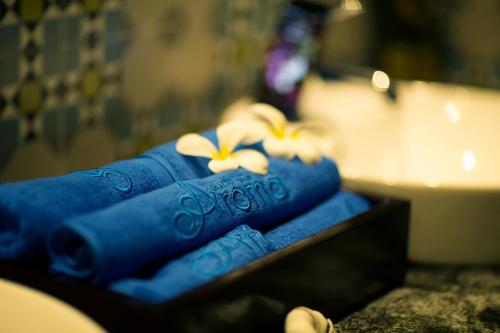 two towels with flowers on them sitting on a table at Alagon City Hotel & Spa in Ho Chi Minh City