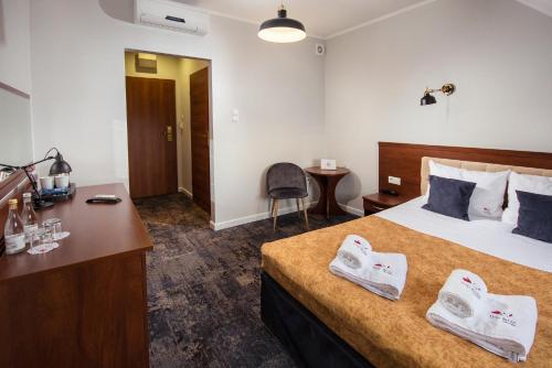 a hotel room with a bed with towels on it at Hotel Trzy Róże in Lublin