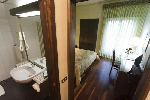 a bathroom with a sink and a bed in a room at Astor Hotel Vintage in Frosinone