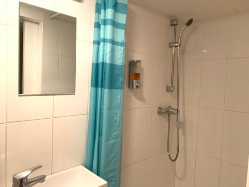 a shower with a blue shower curtain next to a sink at Studio Vieux Lyon in Lyon