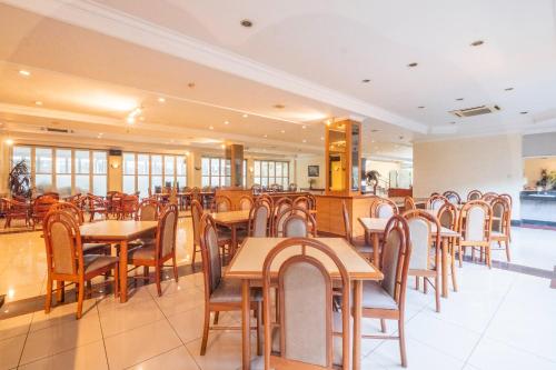 a restaurant with tables and chairs in a room at SUPER OYO Collection O 25 Hotel Baltika in Bandung