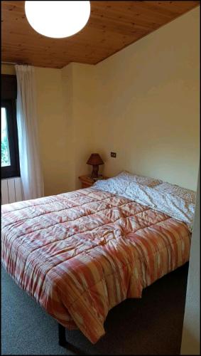 a large bed in a bedroom with a ceiling at trilocale sulle piste da sci in Abetone