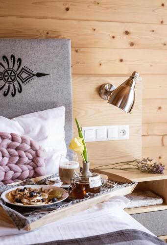 een dienblad met eten op een bed in een kamer bij Willa Malinowa in Zakopane