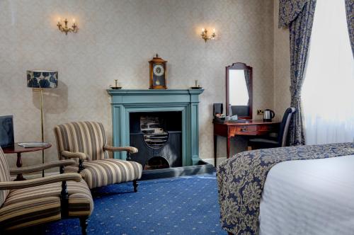 Best Western Forest and Vale Hotel في بيكرينغ: غرفة فندقية فيها موقد وسرير ومرآة