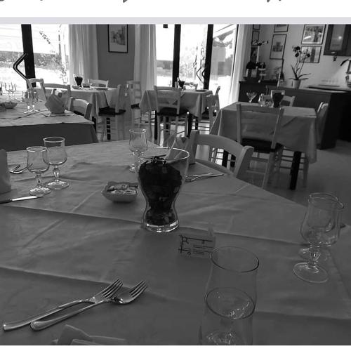 a table with glasses and utensils on a table in a restaurant at B&B la Maison in Sammichele di Bari