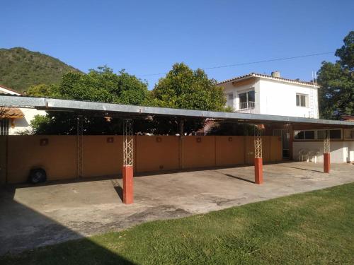 a building with a pavilion in front of a house at la Herradura Dptos in Santa Rosa de Calamuchita