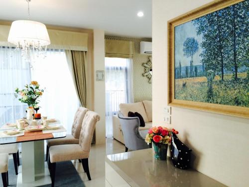 a living room with a table and a dining room at Peters Villa in Ban Nakhon Chum