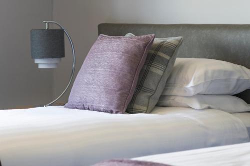 a pile of pillows on a bed in a bedroom at Trethorne Hotel & Golf Club in Launceston