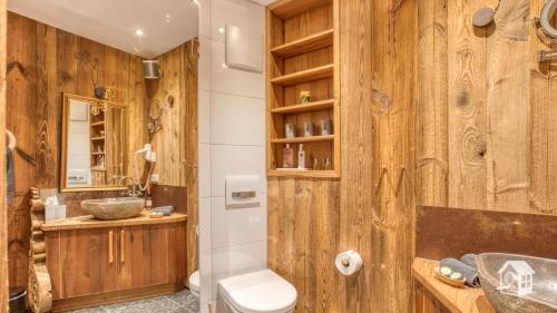 a bathroom with wooden walls and a toilet and a sink at Chalet Harmonie in Inzell