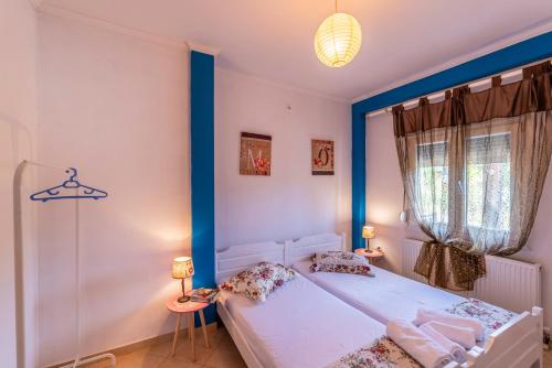 a bedroom with a bed with a blue headboard at Demmy's Apartment in Potamiá