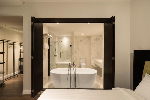 a large bathroom with a tub and a shower at S Ram Leisure Hotel SHA PLUS in Bangkok