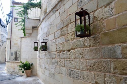 a brick wall with potted plants on it at La Dimora delle Grazie in San Cesario di Lecce