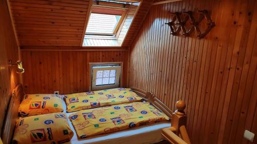 a bedroom with a bed in a wooden room at Guesthouse "Nakvyne pas zveja" Nagliu street in Nida