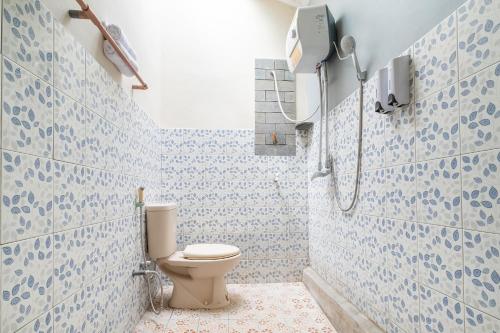 a bathroom with a toilet and a shower at Mettaloka Guesthouse in Magelang