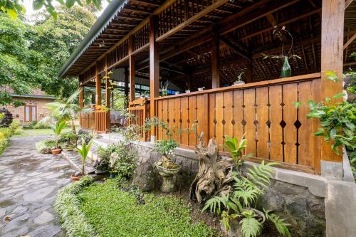a building with a bunch of plants in front of it at Mettaloka Guesthouse in Magelang