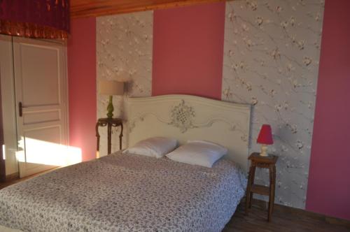 ein Schlafzimmer mit einem weißen Bett mit rosa Wänden in der Unterkunft Ma maison bleue in Saint-Brice-sous-Rânes