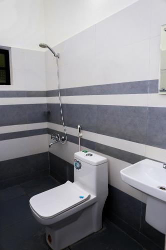 a bathroom with a toilet and a sink at Green Garden Lotus Villa in Wayanad