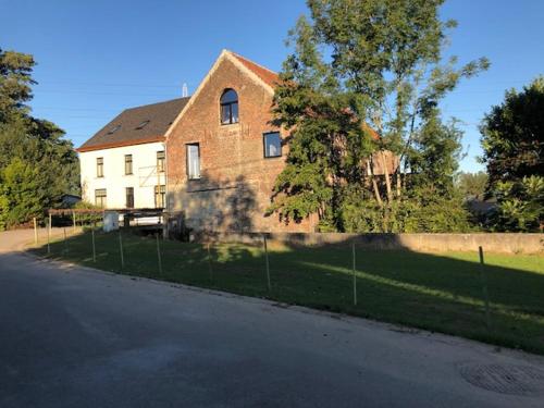 a large brick house on the side of a street at B&B Langeveldemolen in Merchtem