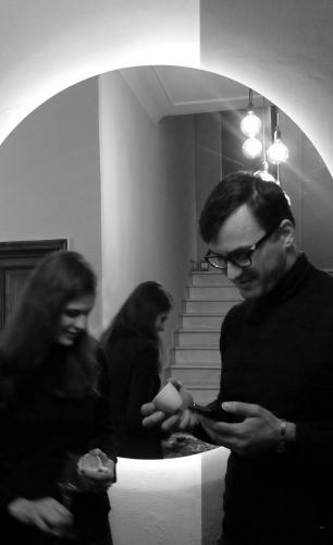 a man looking at his cell phone in front of a mirror at Relais Stibbert Florence in Florence