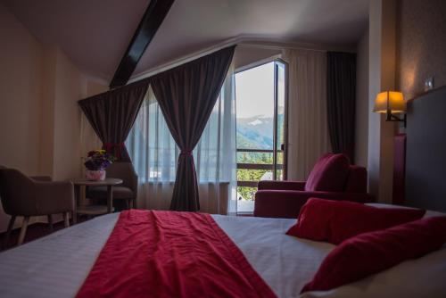 a hotel room with a bed and a large window at Hotel Marea Neagra in Sinaia