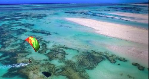 a person in the ocean flying a kite over the ocean at Chuiba Bay lodge in Pemba