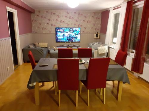 a dining room with a table and chairs and a tv at Holiday Home Byvägen 38 in Nattavaara
