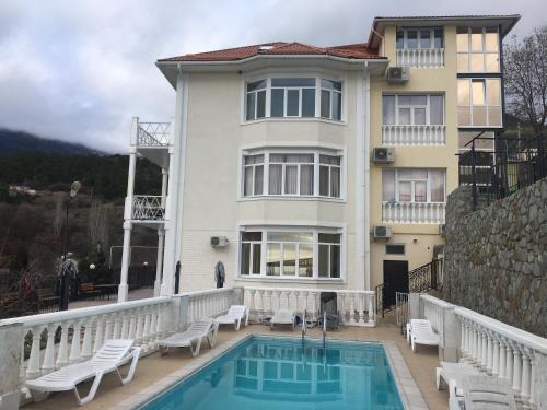 a house with a swimming pool in front of a house at Private house villa Svetlana с сауной и бассейном in Yalta