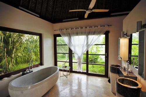 a bathroom with a large tub and large windows at Chuiba Bay lodge in Pemba