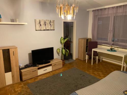 a living room with a flat screen tv and a table at Apartment4you in Graz