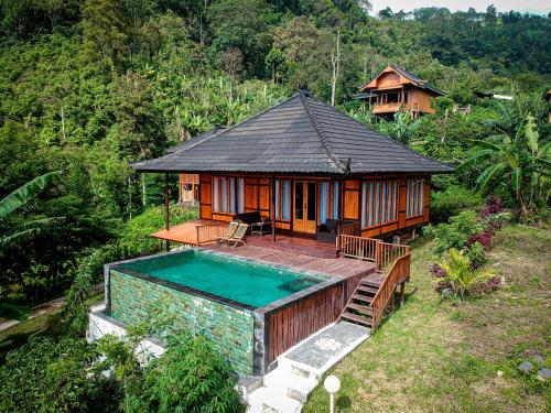 a small house with a swimming pool in front of it at Munduk Menir Villas in Munduk