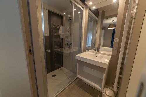 une salle de bain avec une douche en verre et un lavabo dans l'établissement VVF Normandie Veules-les-Roses, à Veules-les-Roses