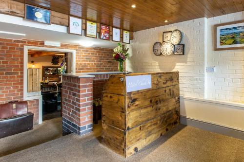 a restaurant with a wooden counter and a brick wall at The Royal Oak in Loughborough