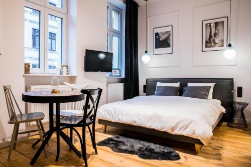 a bedroom with a bed and a table and chairs at Apartamenty Sofa Spot in Toruń