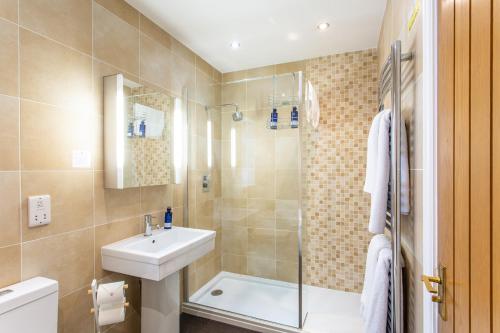La salle de bains est pourvue d'un lavabo, de toilettes et d'une douche. dans l'établissement The Royal Oak, à Loughborough