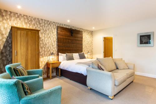 a bedroom with a bed and two chairs at The Royal Oak in Loughborough