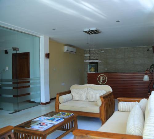 a living room with a couch and a coffee table at PJ Hotels Jaffna in Jaffna
