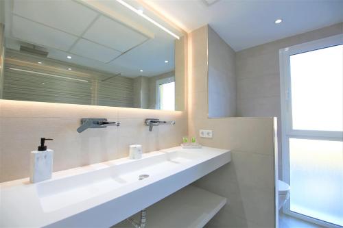 bagno con lavandino e grande specchio di Estepona Port Apartment LUNA a Estepona