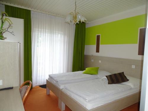 ein Schlafzimmer mit einem Bett mit einer grünen Wand in der Unterkunft Gasthof Torwirt in Lavamünd